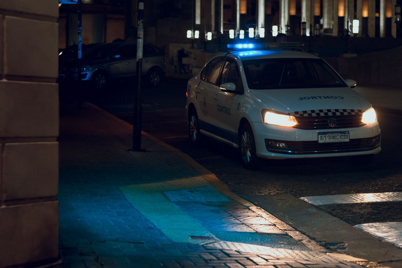 A police vehicle with flashing lights patrolling the streets of Rosario at night.